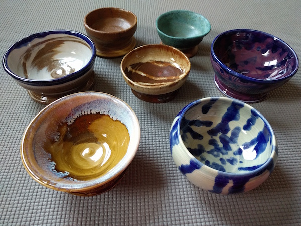 seven colorful bowls arranged in a circle with one in the middle, shown from the side so you can see that they are bowls