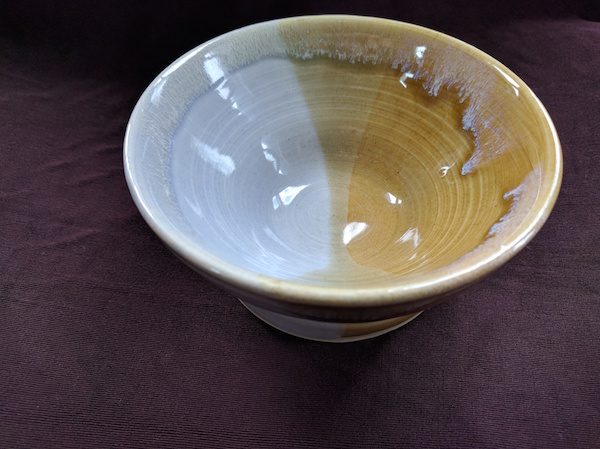 bowl half pale blue and half yellow-gold, with an hourglass-esque pattern where the colors overlap