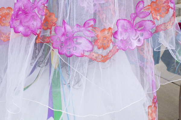 close up of lacy flowers on a veil, colored pink and orange