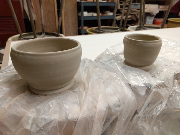 two white clay bowls, taller than they are wide, unglazed