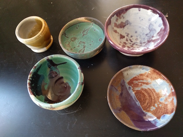 five glazed bowls after firing, shiny and brightly colored