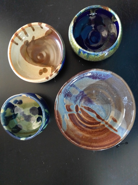 four glazed, fired, colorful shiny bowls