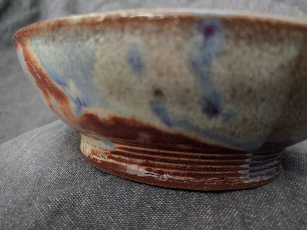 side view of the base of a bowl that has five small ridges circling the bottom before the bowl flares up and out