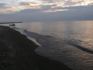 slow lapping waves on a quiet lake beach at twilight