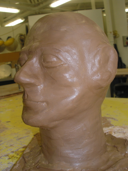 a bald clay head, features smoothed and shiny