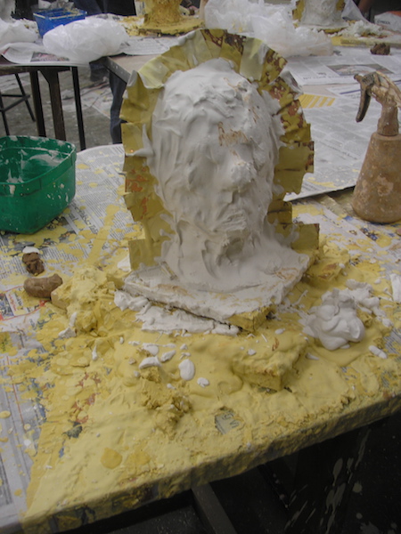 head with metal shim fence, looking blob-like with the last thick coat of plaster applied