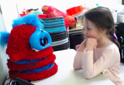child smiling at the tega robot