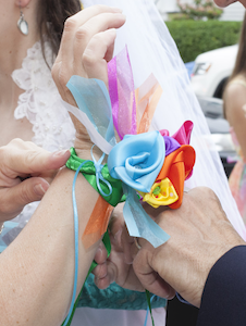 satin ribbon flower corsage being tied on to a woman's wrist