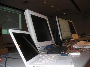_four computers in a row on a table_