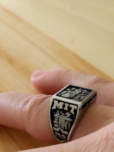 close up of a hand wearing a silver and black MIT ring