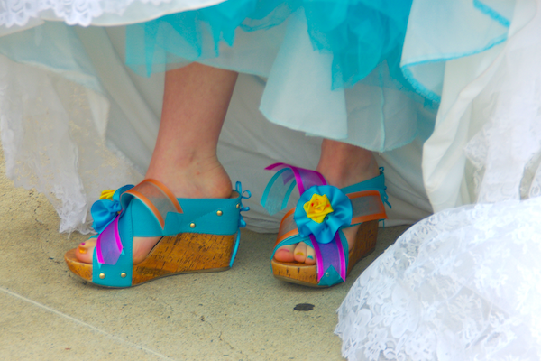 cork wedge sandals with thick turquoise straps and ribbon flowers attached over the toes 